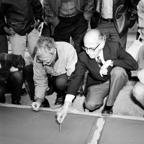 John Stewart and Jonas Salk writing names in cement, Muir College, UC San Diego