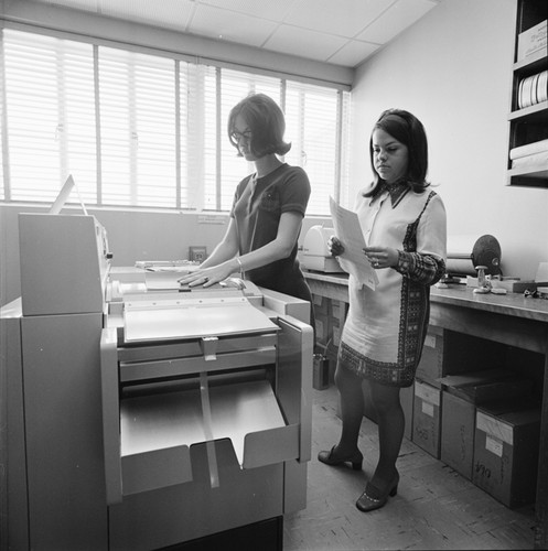 Women using photocopy machine, Central Duplicating Center, UC San Diego