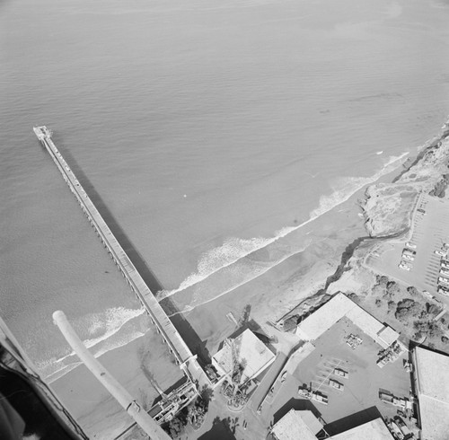 Aerial view of Scripps Institution of Oceanography pier, with volcanic dike rock visible underwater north of the pier