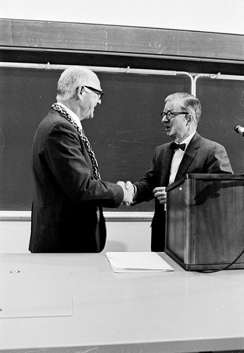 William D. McElroy (left) shaking hands with Charles J. Hitch during inauguration ceremony