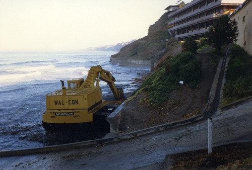 Construction equipment on the beach at high tide during Ellen Browning Scripps Memorial Pier construction, Scripps Institution of Oceanography