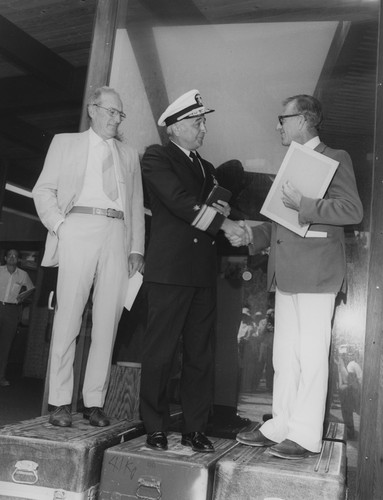 Walter H. Munk (right) receiving award from a U.S. Navy officer, with William A. Nierenberg (left)