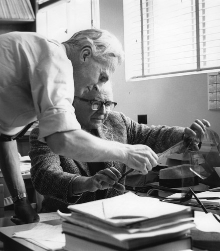 P. F. Scholander (sitting) and an unidentified man reviewing a film strip in Scholander’s office, Scripps Institution of Oceanography