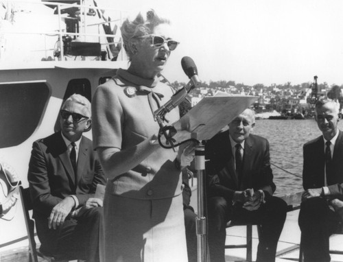 Ellen Revelle giving speech and Roger Revelle (background) at dedication of R/V Ellen B. Scripps