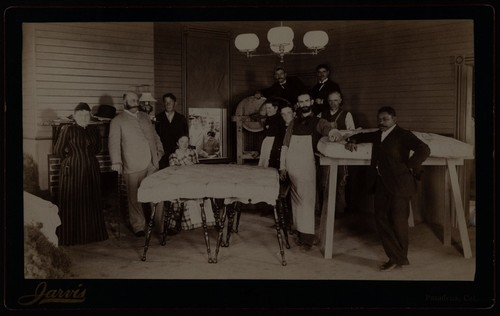 Photograph of an African American man with mattress factory workers