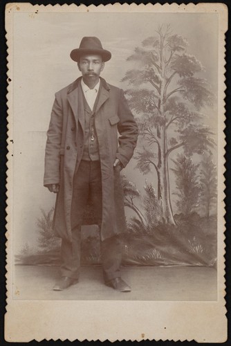 Photograph of an African American man in overcoat and hat
