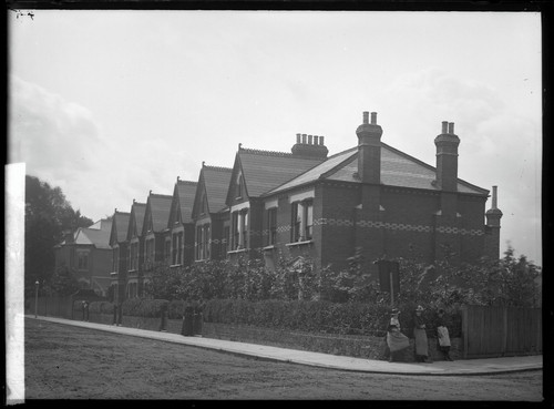 Row houses with three women standing on corner. [negative]