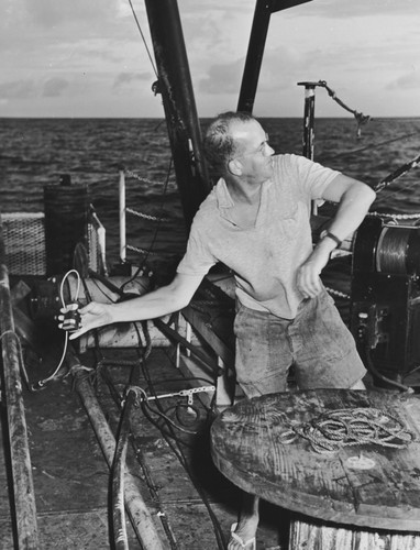 Russell W. Raitt throws a TNT charge into the ocean from R/V Spencer F. Baird