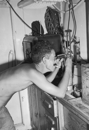 Theodore Folsom uses scientific instruments aboard R/V Spencer F. Baird