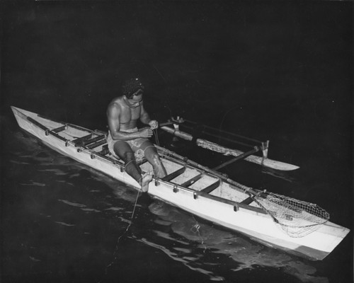 Fisherman fishes from his canoe, off Fiji