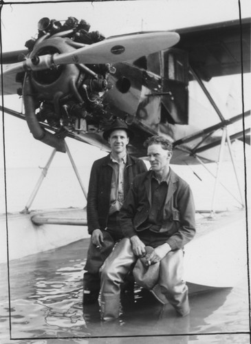 Men with seaplane, on shore at Snag Point, Alaska