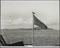 Scene from stern of ferry boat flying US flag, San Francisco Bay, California, 1920s
