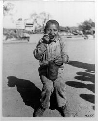 A boy eating from a jar of fruit