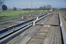 Foley & Burk Shows flatcars on tracks at east of Sebastopol, Mar. 1972