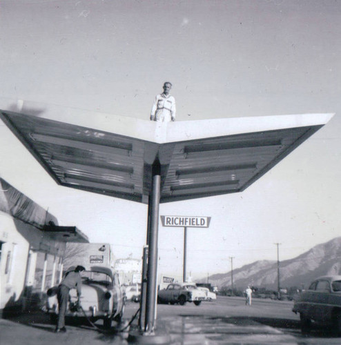 Pete Bryant on roof of his garage and service station on East Ramsey Street in Banning, California