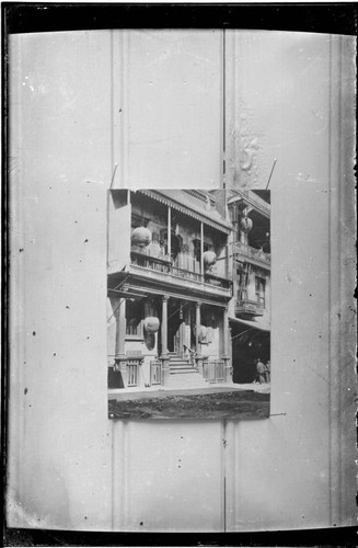 Copy photograph of a three-story building with hanging lanterns