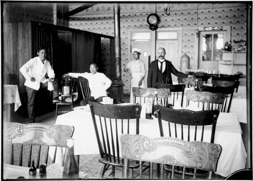 Three Chinese men and one white man inside a restaurant