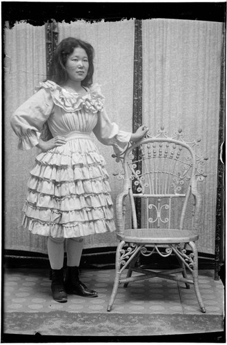 Portrait of a Chinese woman, standing, wearing dress with ruffles