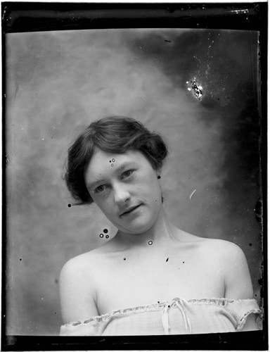 Head-shot portrait of a woman, with bare shoulders