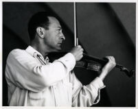 Jascha Heifetz playing the violin, 1957 [descriptive]