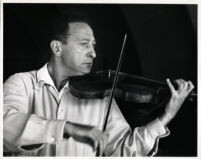 Jascha Heifetz playing the violin, 1957 [descriptive]