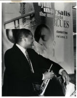 Wynton Marsalis posing in front of a poster of himself, 1986 [descriptive]