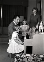 Vice President Richard Nixon playing the piano for Julie, Tricia, and Pat Nixon