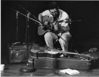 Eugene Chadbourne playing guitar, 1977 [descriptive]
