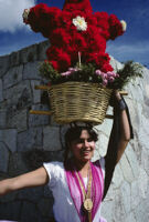 Chines de Oaxaca, woman holding flower basket on head, 1982