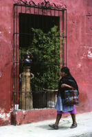 Oaxaca, woman walking by barred window, 1982 or 1985