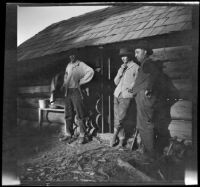 James Bidwell, Charles "Mack" Bidwell, and Adolph Bystle at the entrance of a log cabin, Shasta County vicinity, 1915