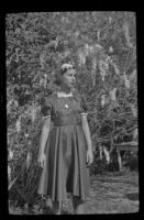 Dorothea Siemsen stands in front a wisteria plant in her grandfather, H. H. West's backyard, Los Angeles, 1942