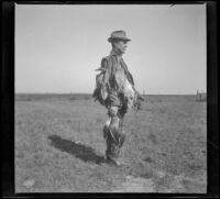 John T. Bailey poses with ducks from a shoot, Orange County vicinity, about 1912