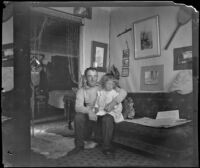 Bob Brain and Aileen Brain sitting on their sofa, Santa Monica, [about 1900]