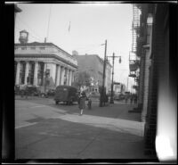 Mertie West stands in front of an old bank building near the corner of Arch and North 3rd Streets, [Philadelphia], 1947