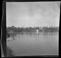 Lake in MacArthur (Westlake) Park with trees and houses in the distance, Los Angeles, about 1898