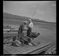 Wayne West and Forrest Whitaker stand on the dock at Uncle Tom's landing with their fishing gear, Big Bear Lake, 1944