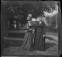 Louise Parsons and Nella A. Brydolf pose on the front lawn with a cat, Burlington, 1900