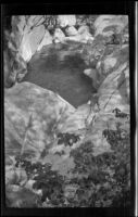 A man fishes a pool that lies between the boulders, Monrovia vicinity, about 1935