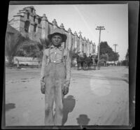 Unidentified boy standing outside San Gabriel Mission, San Gabriel, about 1896