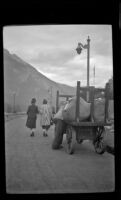 Mertie West and Mrs. Wesley walk up the platform while waiting for a train, Field, 1947