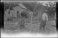 Clarence Cline watching a small water wheel run, probably in Kanab or Fredonia, 1923