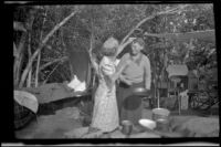 Mertie West touches Agnes Whitaker's hair at a campsite at Rock Creek, Mammoth Lakes vicinity, 1940