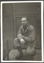 H. H. West, Jr. kneels and poses in front of his barracks at Fort Mears (photo, recto), Dutch Harbor, 1942