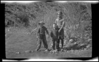 Ambrose Cline, H. H. West, Jr. and Keyo standing alongside a stream, San Francisquito Canyon, about 1923