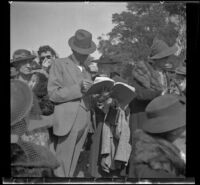 Ralph Hiatt looks at a book at the Iowa Picnic in Lincoln Park, Los Angeles, 1939