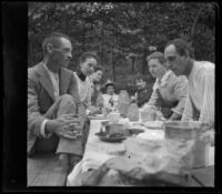 H. H. West sits at the head of a picnic table with friends and cousins, Elliott vicinity, 1900