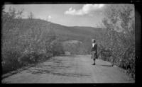 Mertie West stands in the middle of the road that leads to the airport, Circle vicinity, 1946