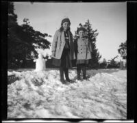 Elizabeth and Frances West posing next to the snowman they made, Mount Wilson, 1909