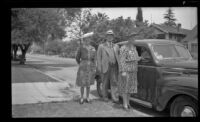 Mertie West, Will H. Shaw and Josie Shaw pose beside a car parked in front of H. H. West's residence, Los Angeles, 1943